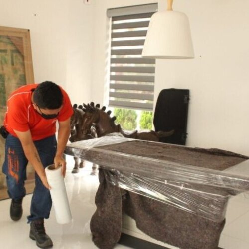 Empleado de santaMaria Trasteos empacando mesa para transportar